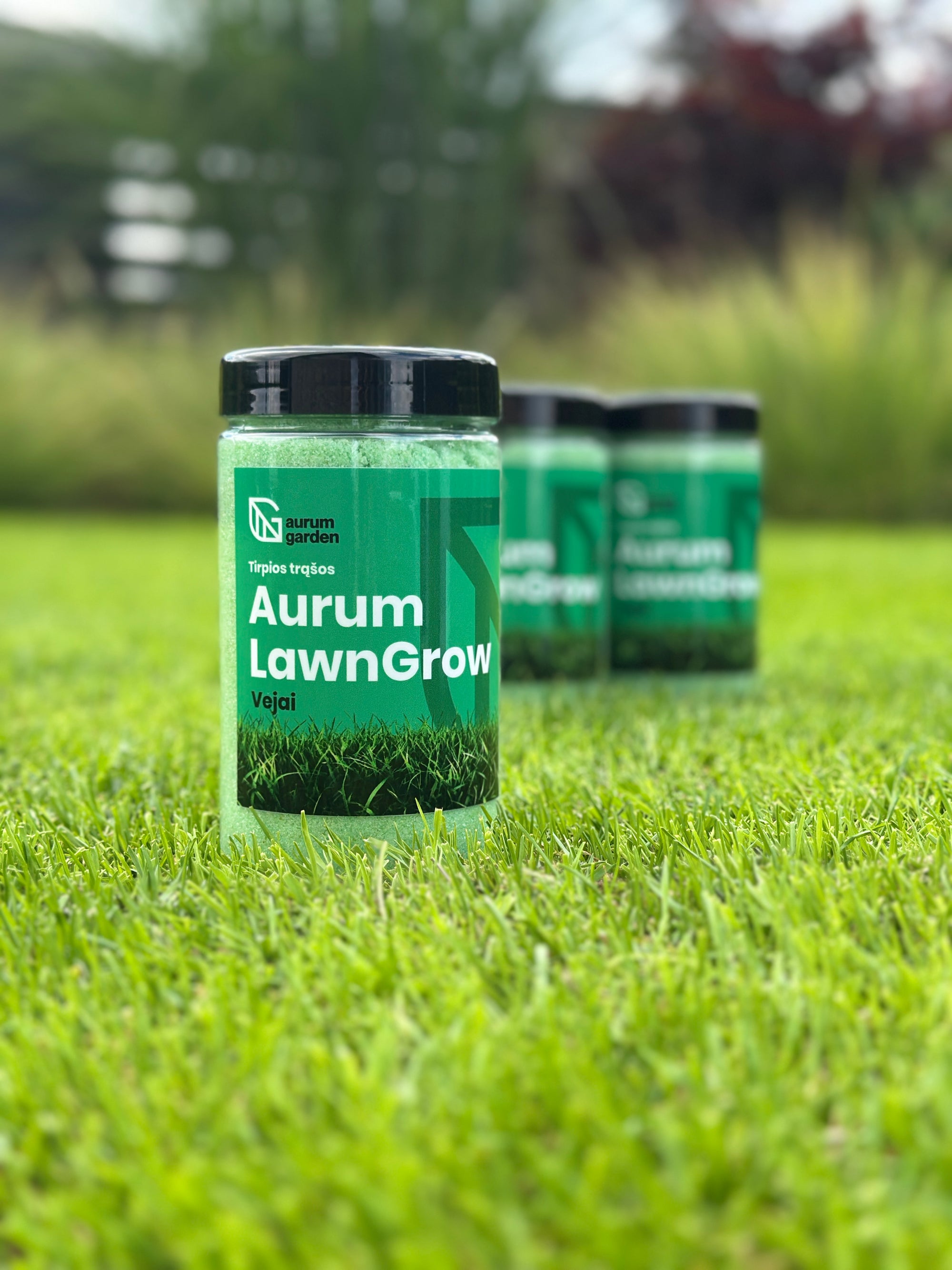 Aurum LawnGrow tirpių NPK trąšų pakuotė stovi žalioje vejoje.