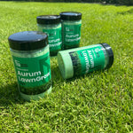 Aurum LawnGrow tirpių NPK trąšų pakuotė stovi vejoje.