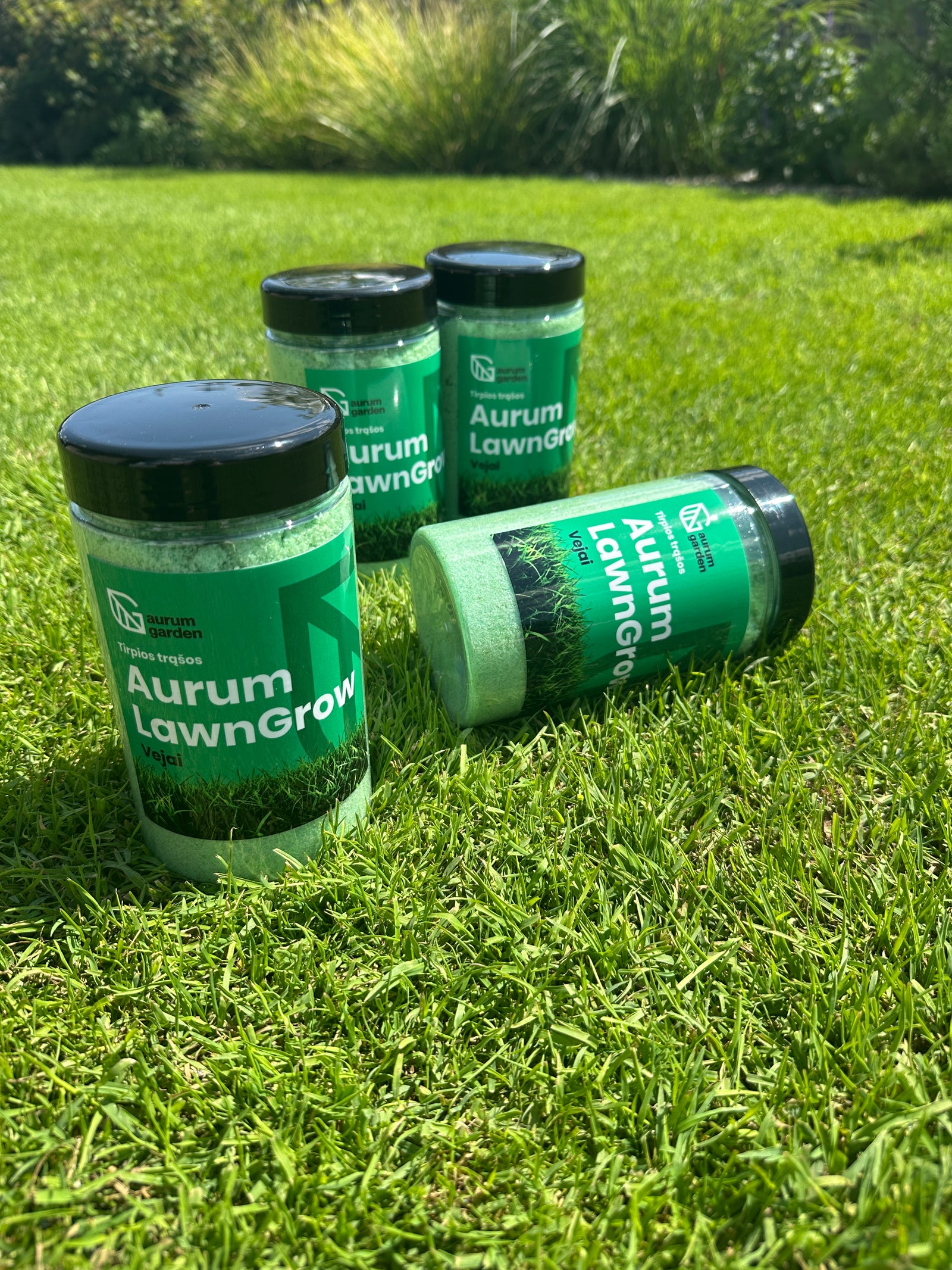 Aurum LawnGrow tirpių NPK trąšų pakuotė stovi vejoje.