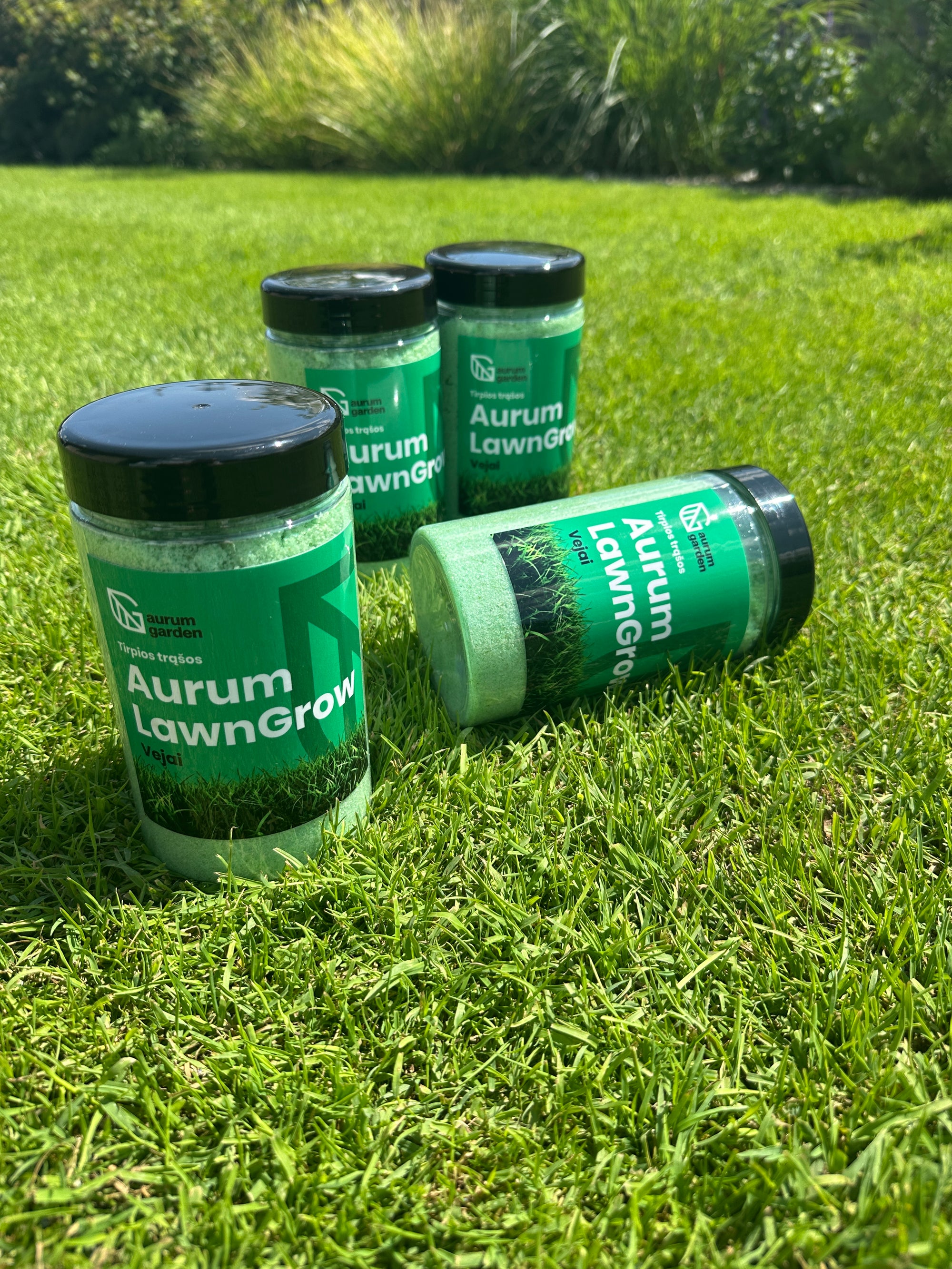 Aurum LawnGrow tirpių NPK trąšų pakuotė stovi vejoje.