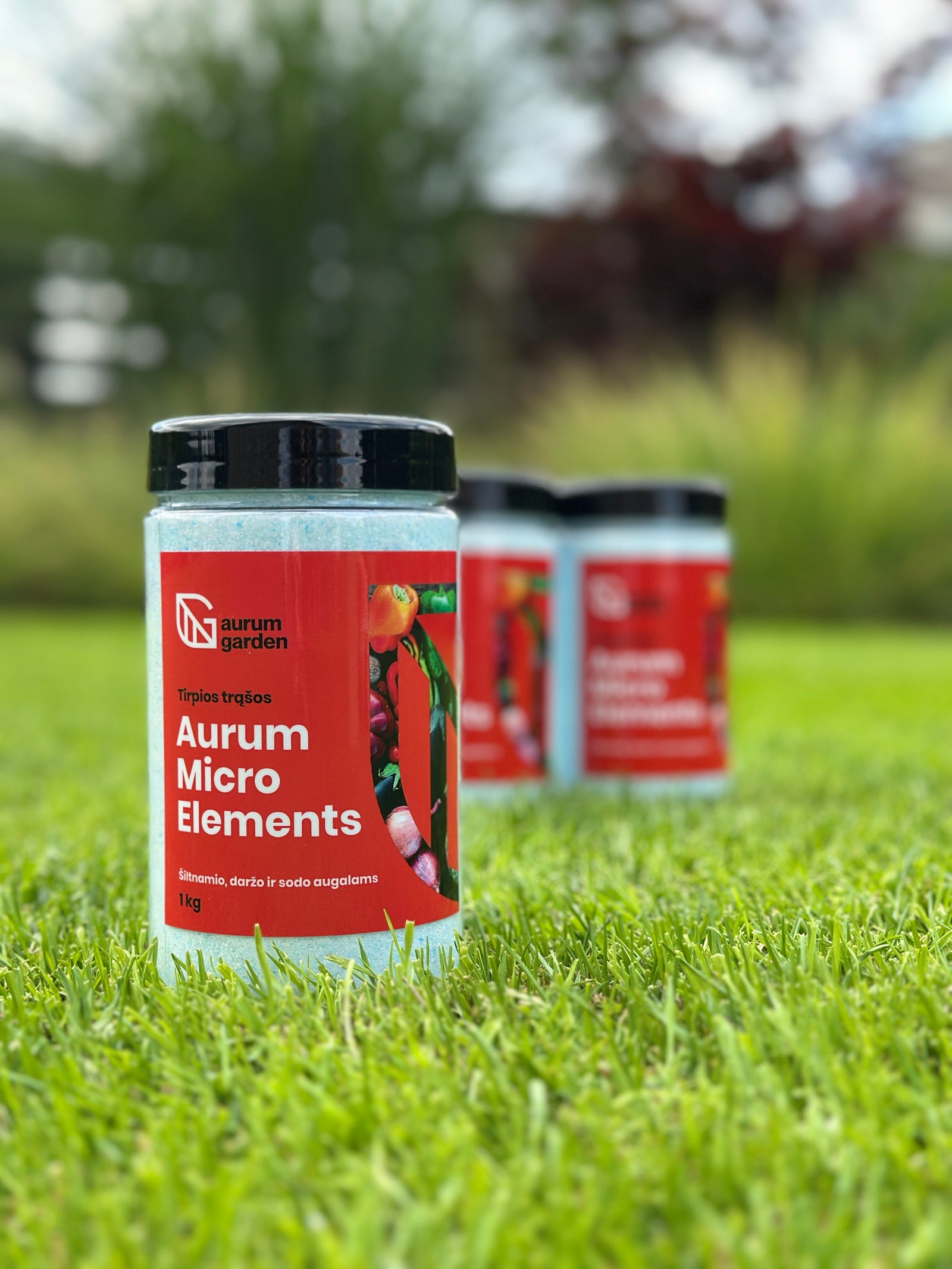 Greito poveikio mikroelementų kompleksas daržui ir sodui "Aurum Micro Elements". Produkto pakuotė pavaizduota sode ant žalios vejos.